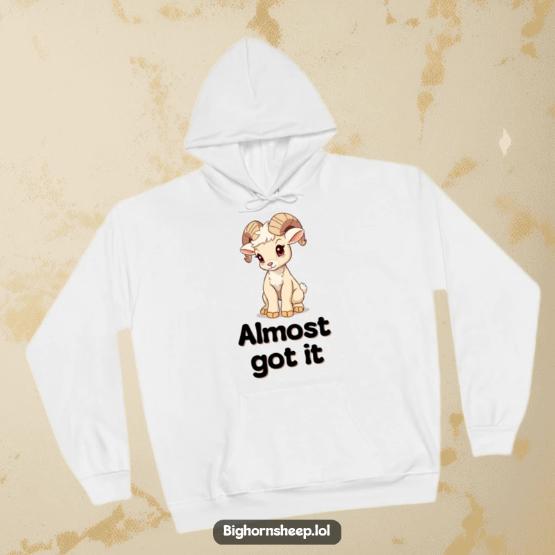Funny bighorn sheep cub hoodie, attempting a majestic pose with a wobble, a cozy and humorous piece celebrating effort.